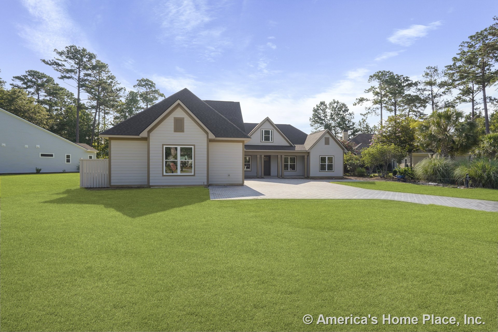 Light-toned horizontal lap siding with multiple gabled rooflines, covered front porch supported by columns, large front windows, paved driveway, decorative trim accents, and