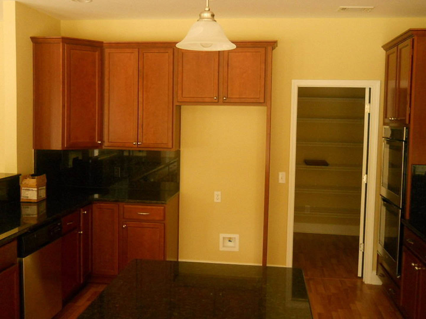 Modern kitchen with matte black countertop, white cabinetry, stainless steel sink, and built-in appliances