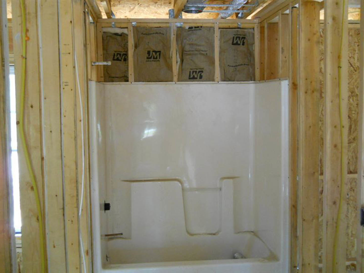 Walk-in shower with glass enclosure, white tile walls, and chrome fixtures in a modern bathroom