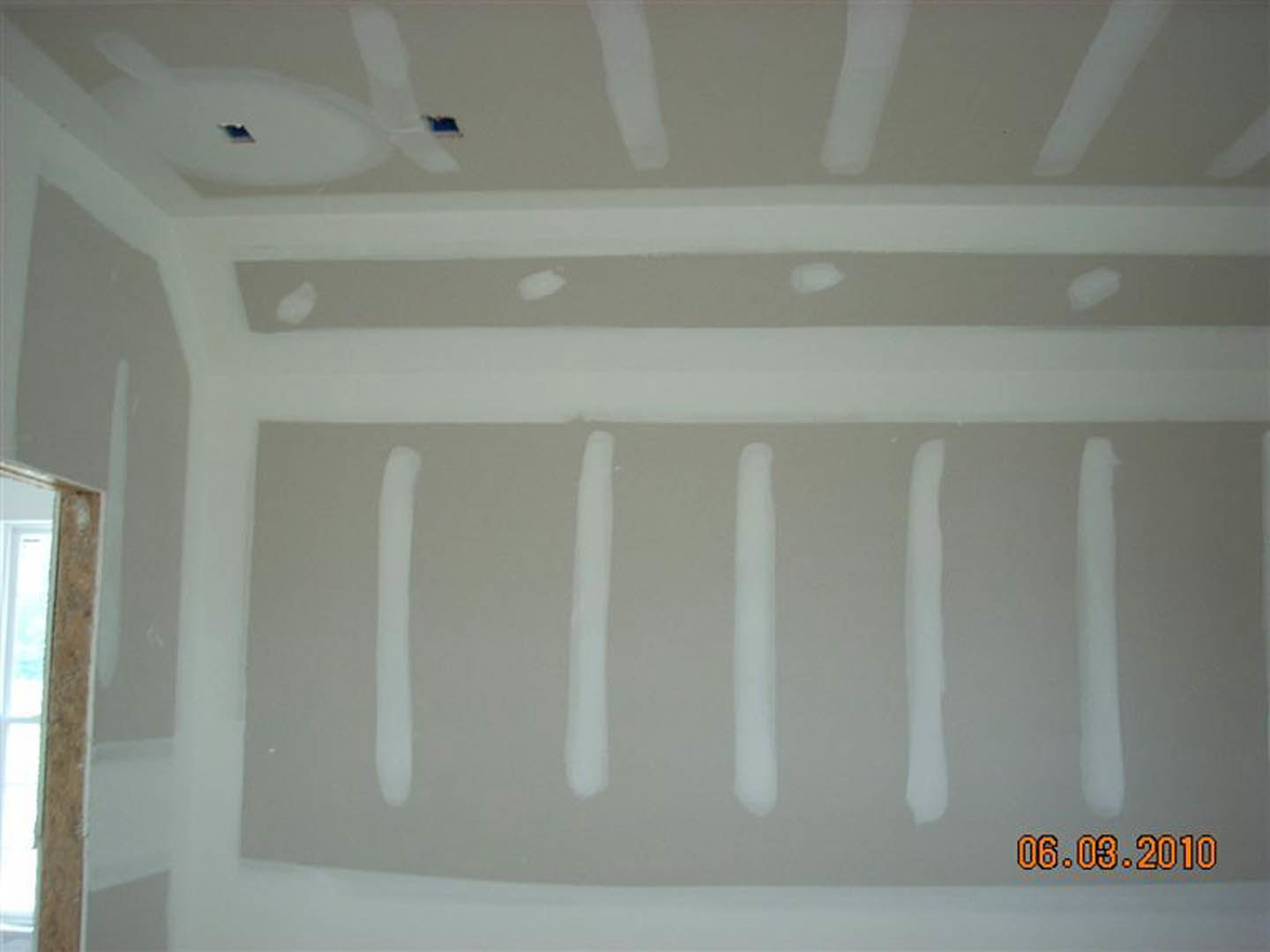 White-painted walls with black molding, white ceiling, window, and white toilet in a modern interior room