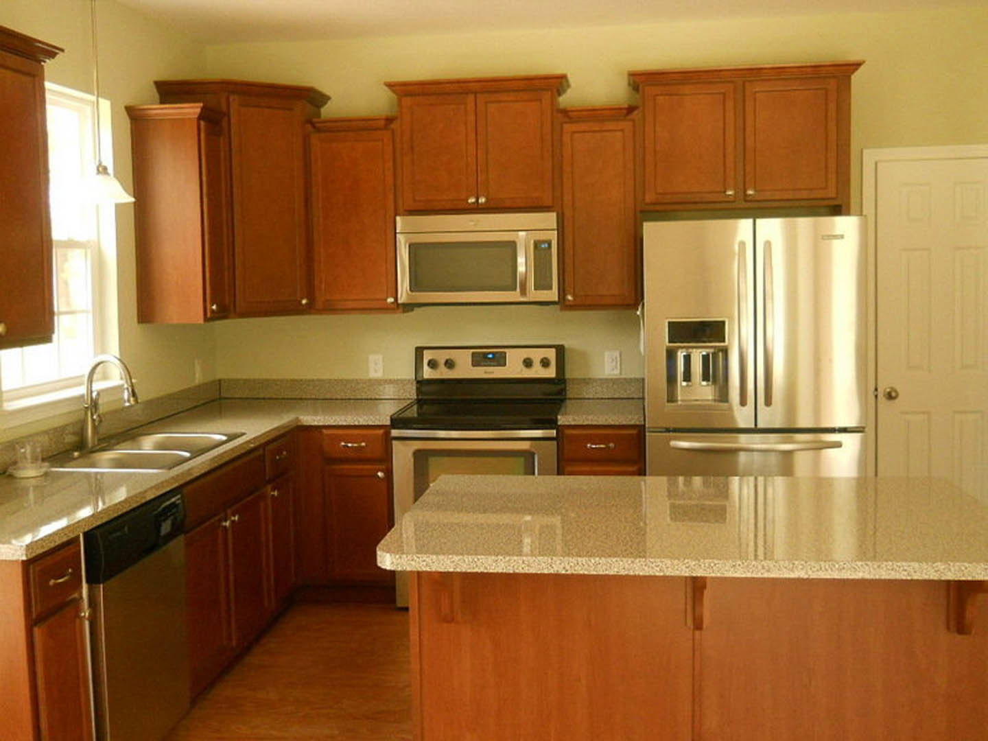 Kitchen with stainless steel refrigerator, stainless steel stove, open microwave, white cabinetry, stone countertop, chrome faucet