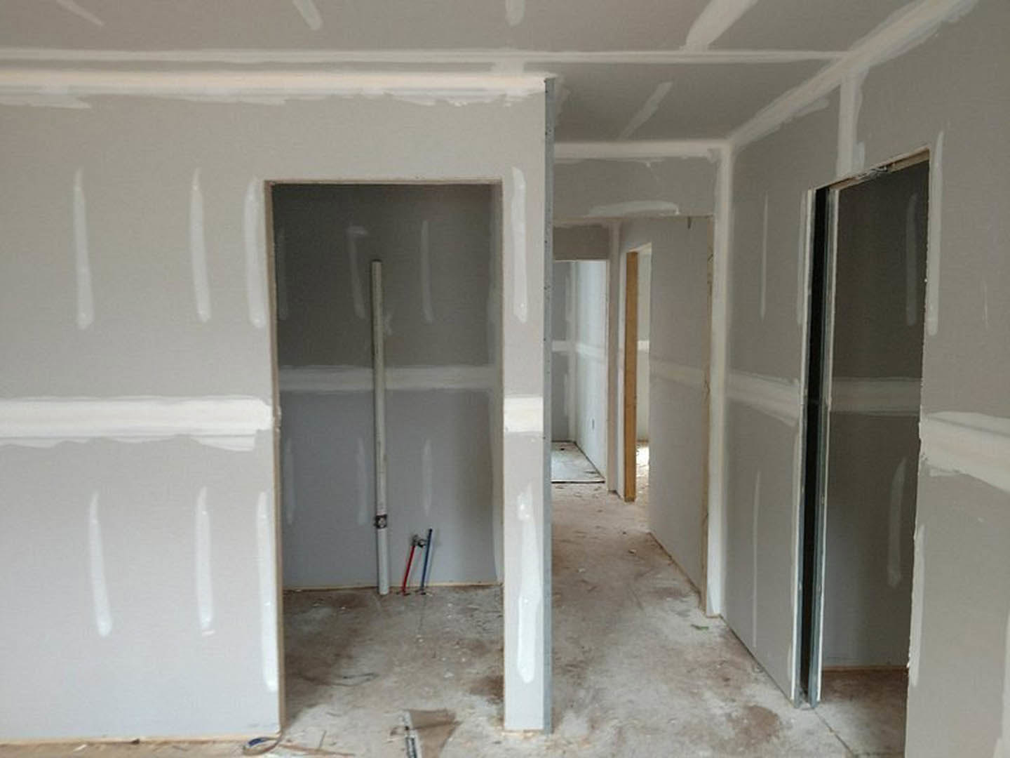 White-painted walls, white door, black trim, and window in a minimalist interior room