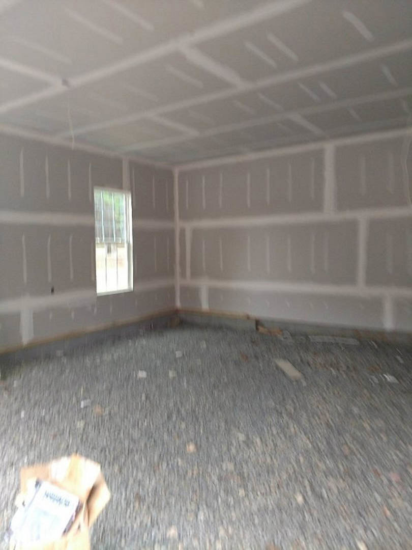 White ceiling with square pattern, grey and white composite floor, plaster walls, large window letting in natural light