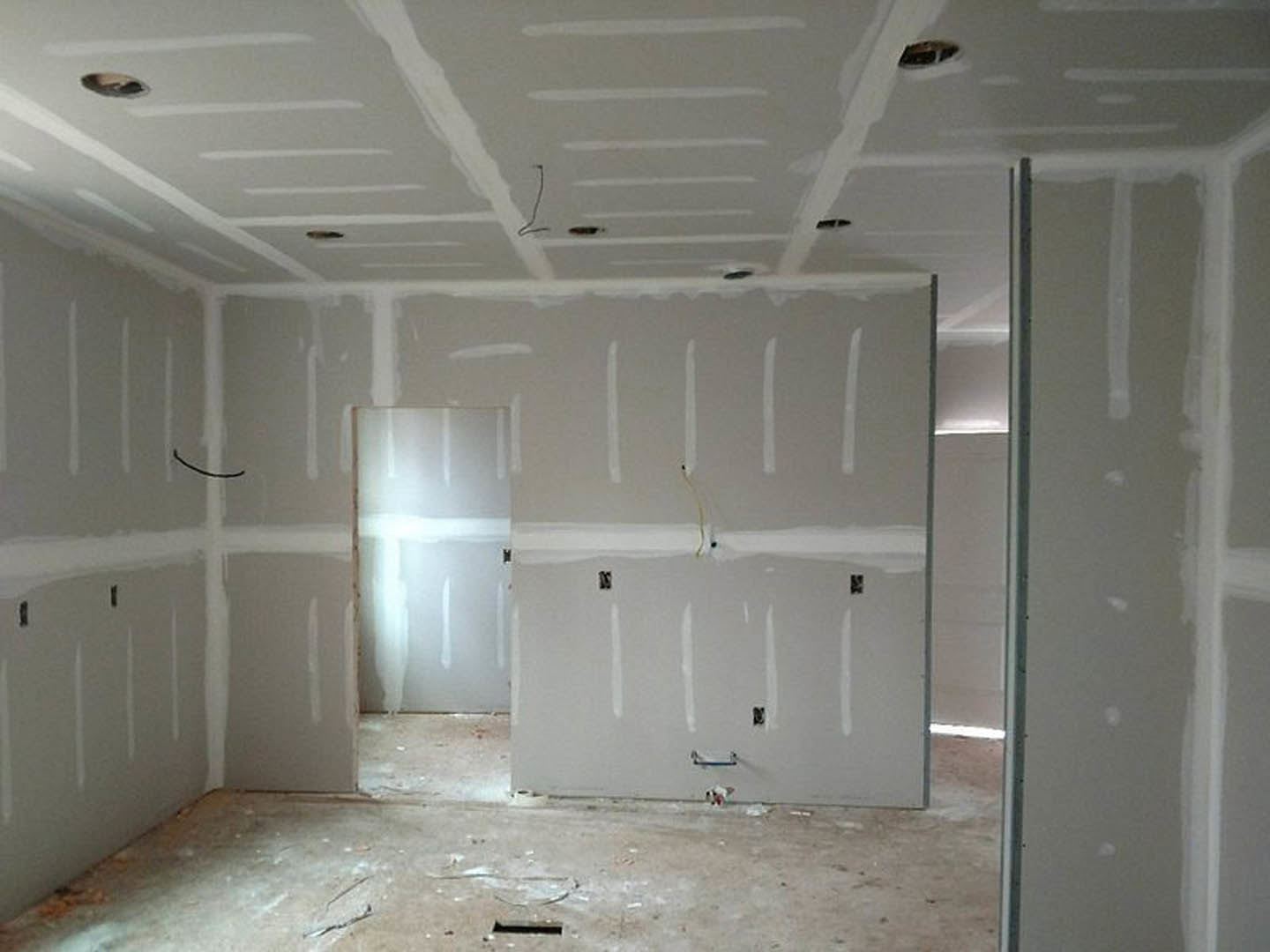 White-walled room with crisp white trim, smooth plaster surfaces, concrete flooring, and a gray-framed whiteboard.
