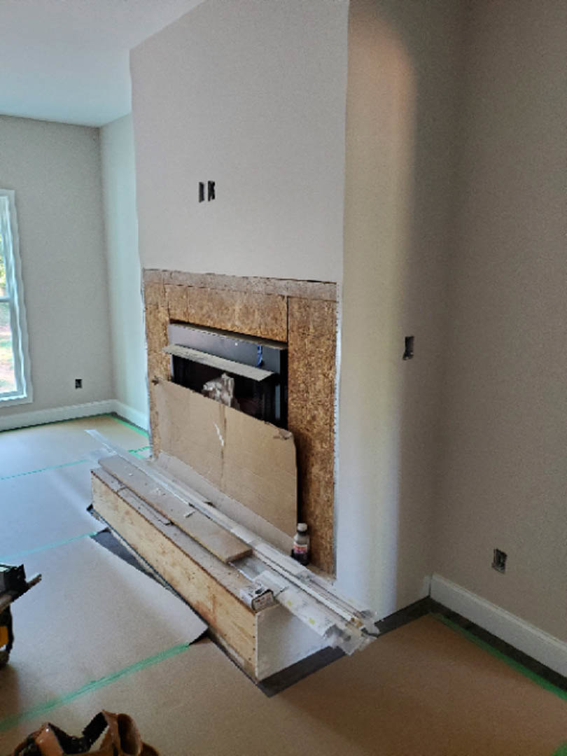 Modern living room with plaster fireplace, wood mantel, light laminate flooring, and white ceiling