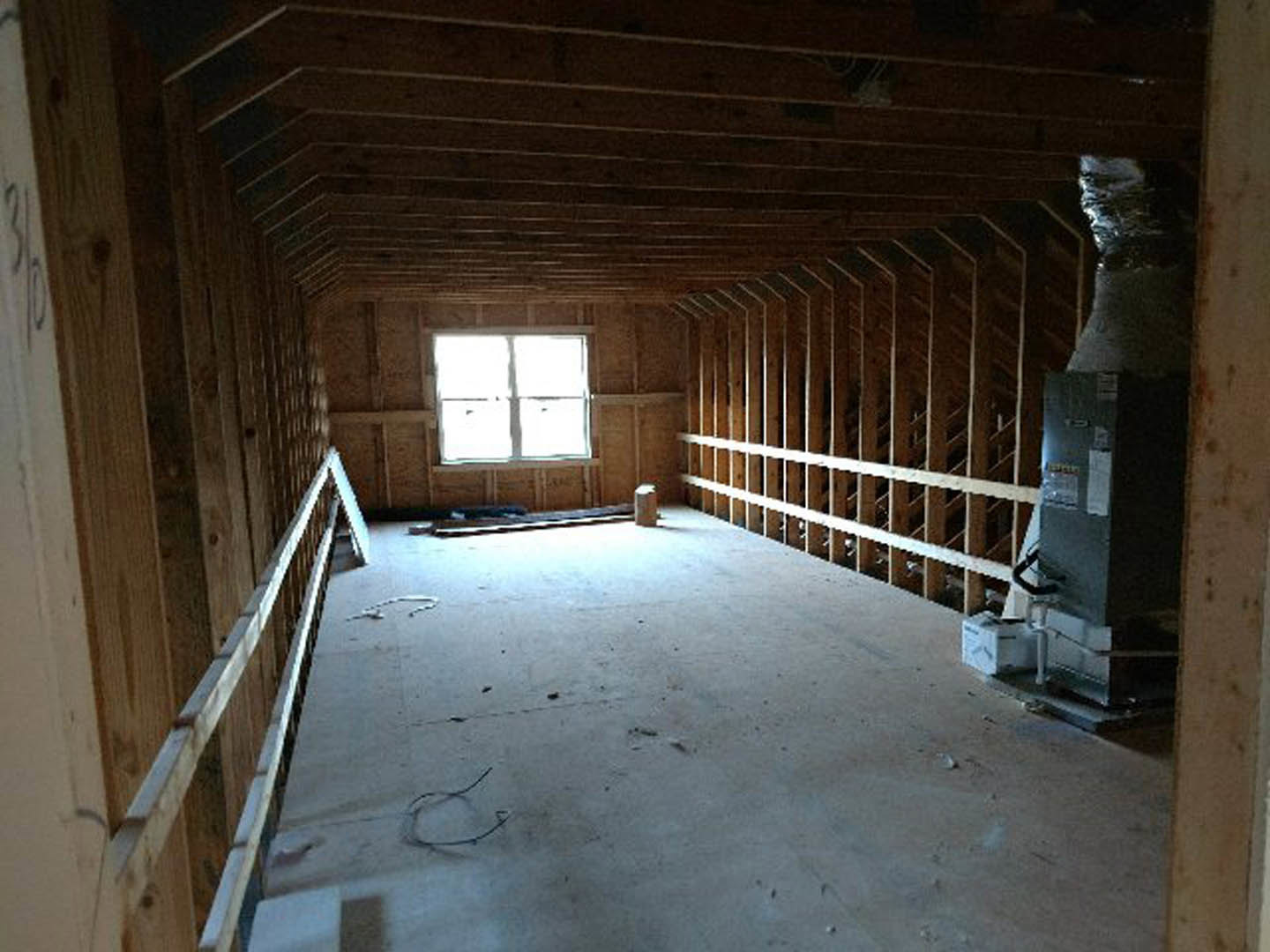 Room with dark wood walls, wooden shelves, window letting in natural light, ceiling vent, and wooden railing along walkway