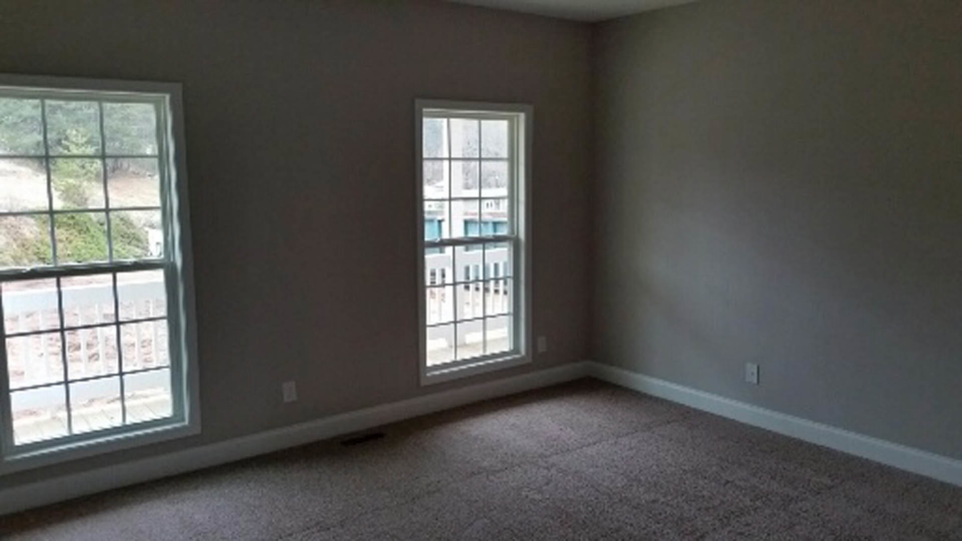 Bright room with large window, white walls, light wood flooring, and window blinds