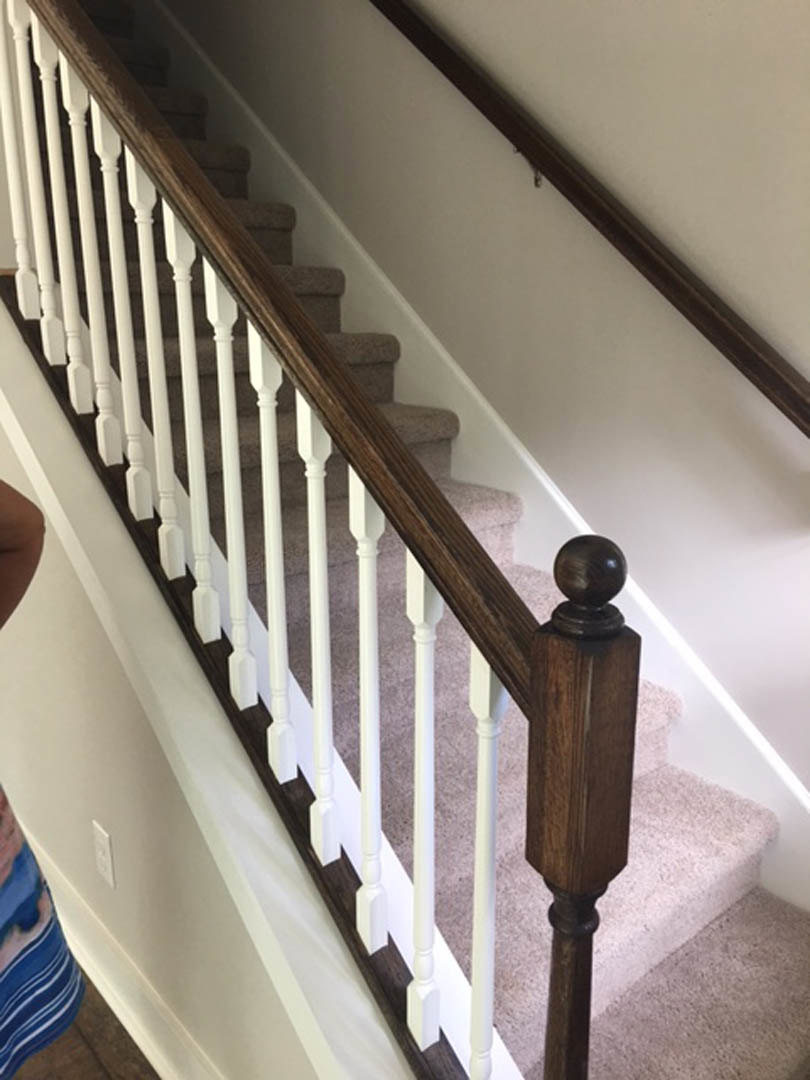 White staircase with matching railings, wood steps, and light-colored walls in a residential interior