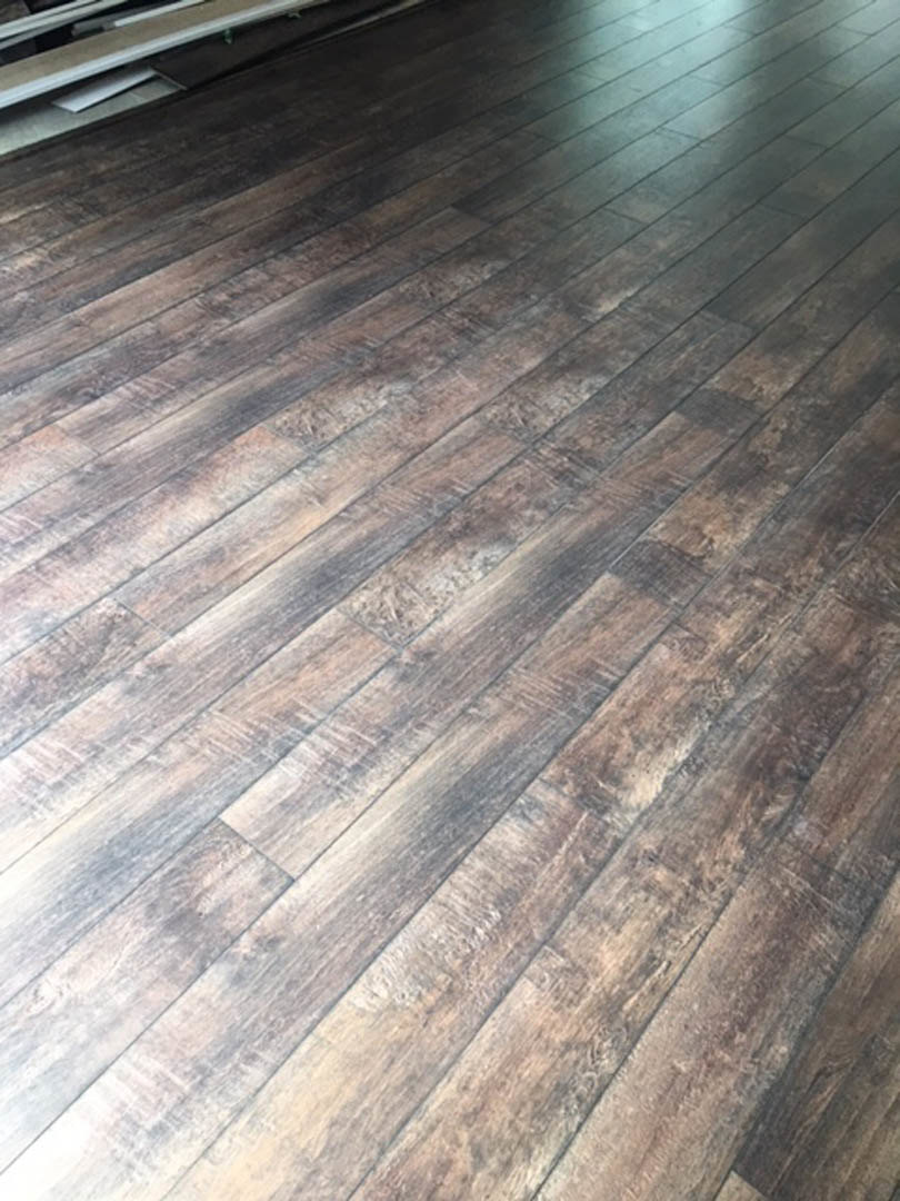 Sunlight illuminating natural wood plank flooring with visible grain and smooth varnished finish
