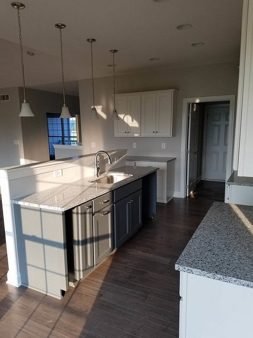 Granite countertops with undermount sink, white cabinetry, tile backsplash, stainless steel faucet, recessed ceiling lighting
