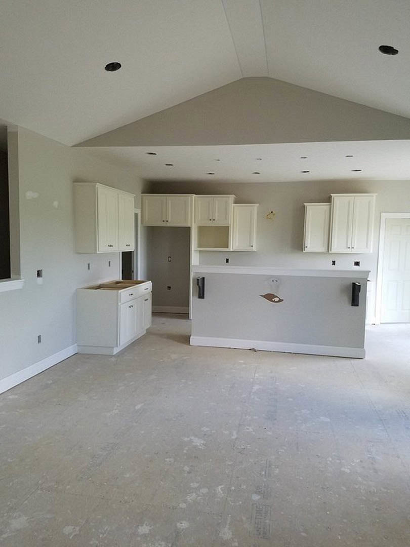 Kitchen with white shaker cabinets, white quartz countertops, white ceiling, stainless steel sink, and light-colored tile flooring