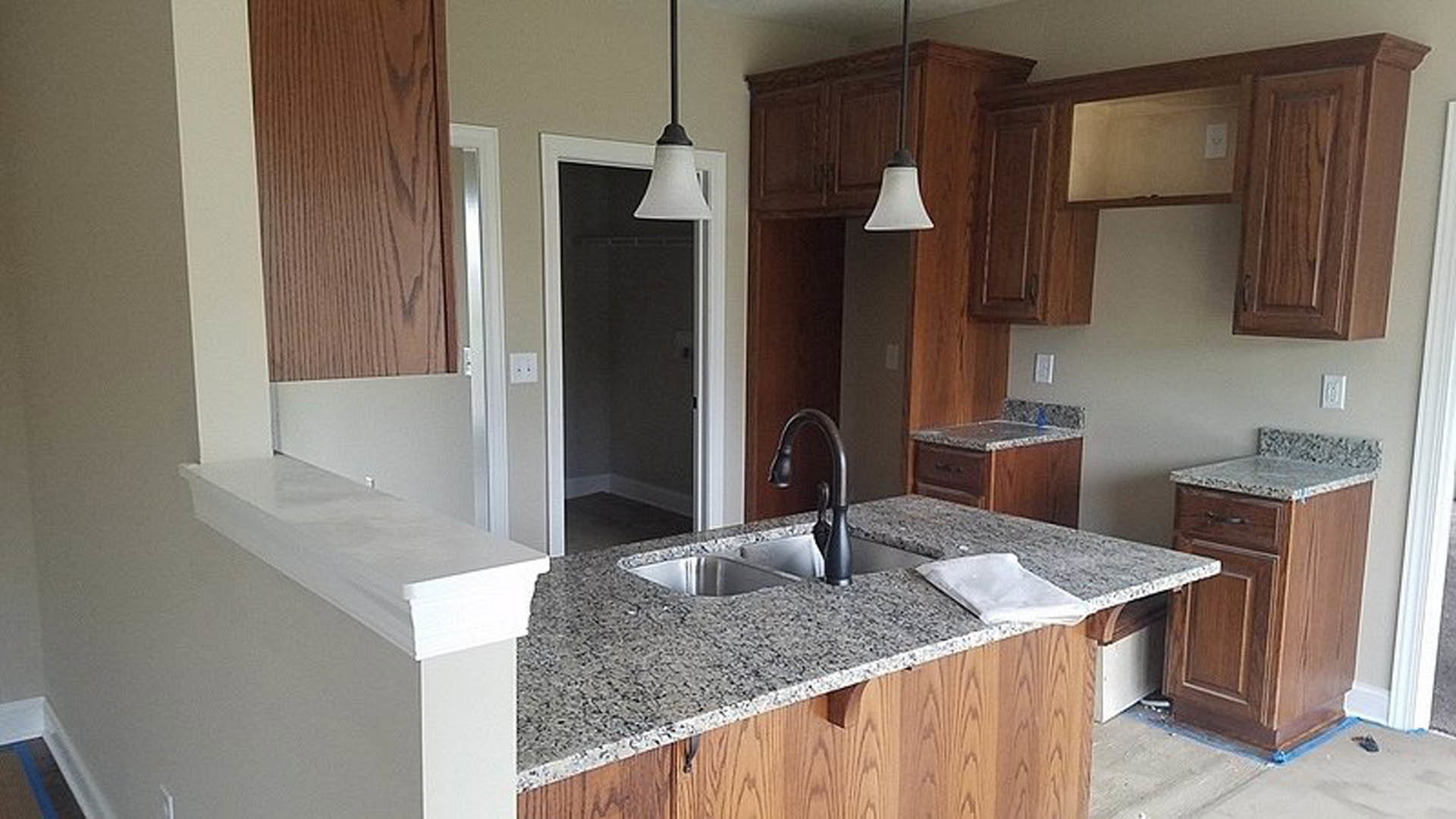 Granite countertops with white cabinetry, stainless steel faucet, undermount sink, and modern kitchen appliances