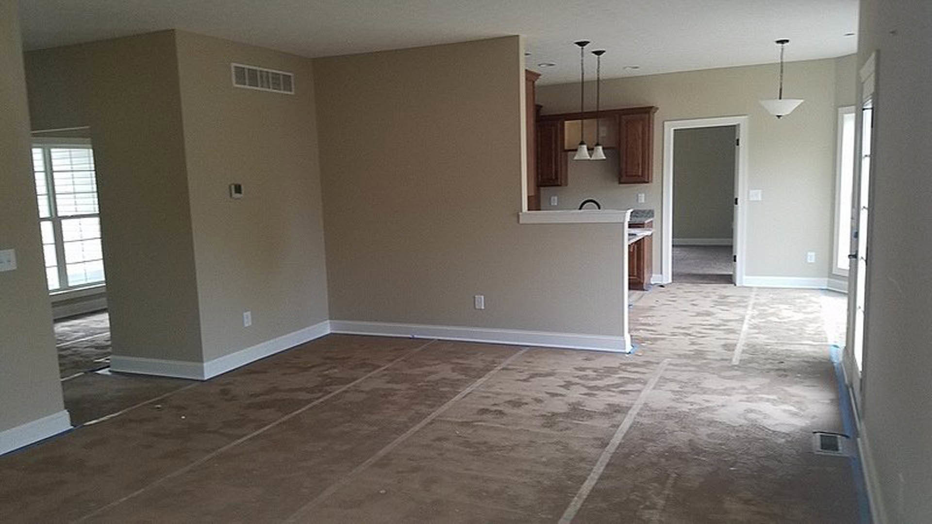 Living room with light carpet flooring, neutral walls, white trim, and a large doorway leading to adjacent spaces
