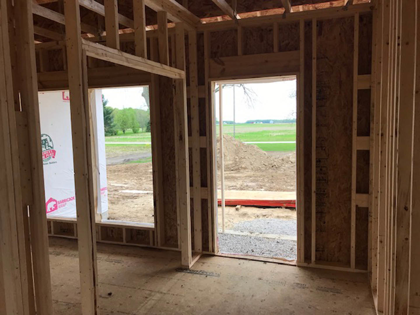 Wood plank flooring, white walls, large windows, and a wooden door in a bright interior room