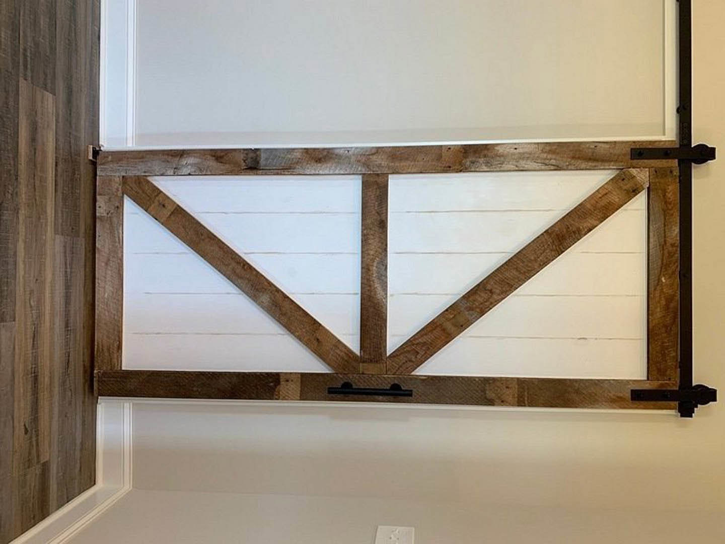 White door framed by vertical brown wood planks on a smooth white wall