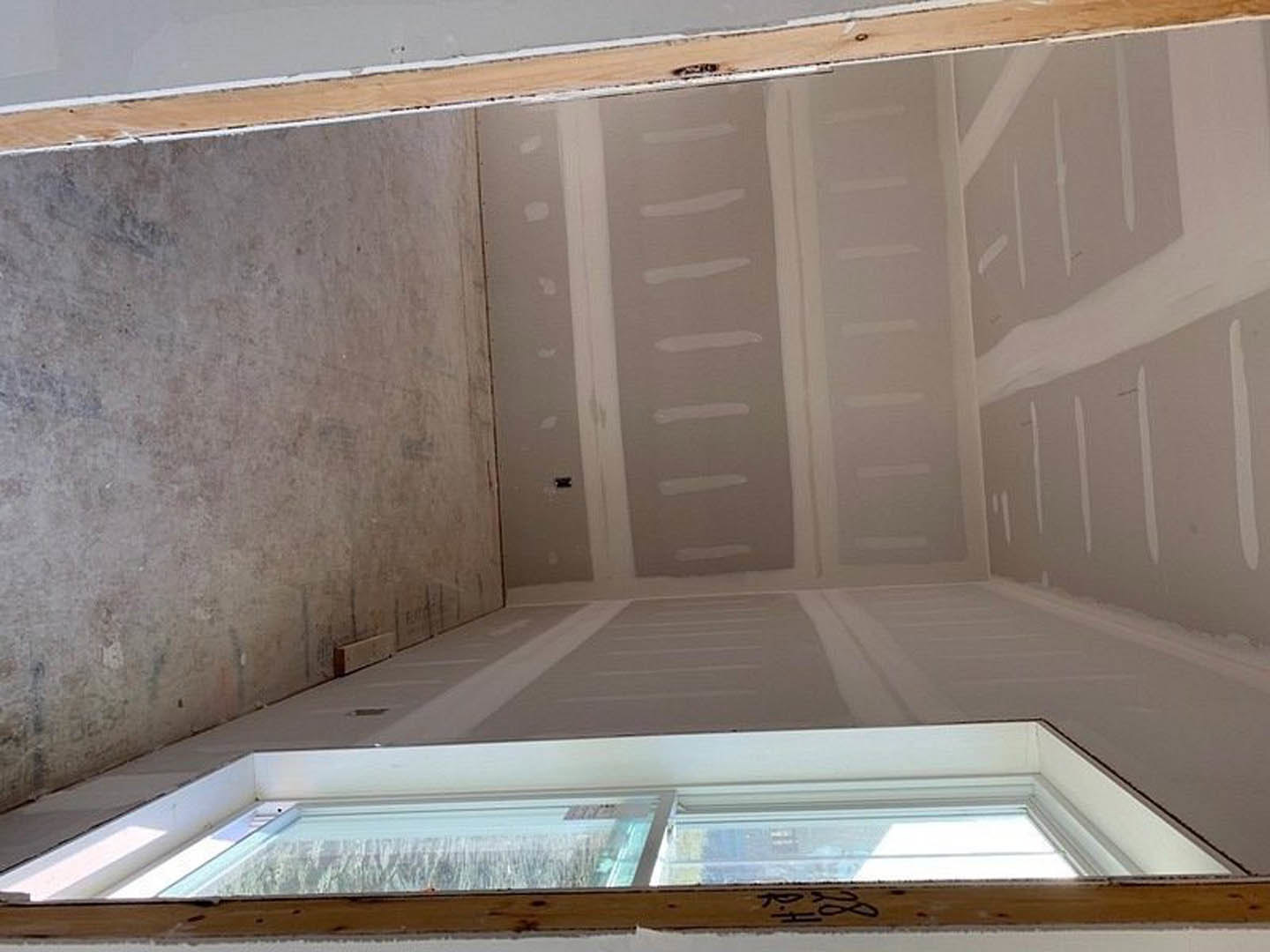 White-painted walls, open door, carpeted floor, wood shelf, and large window with marble sill in a residential room