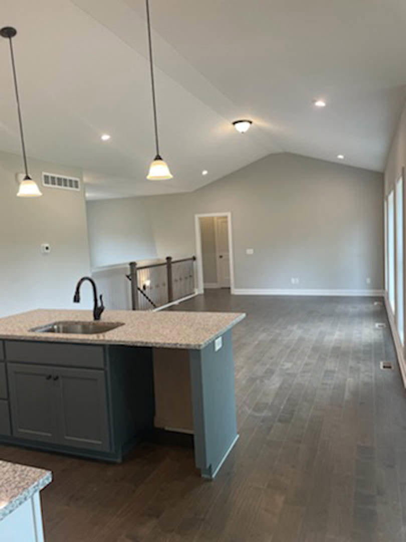 Open-concept kitchen and living room featuring wood flooring and matching wood ceiling, tile backsplash, modern cabinetry, stone countertop with sink and tap