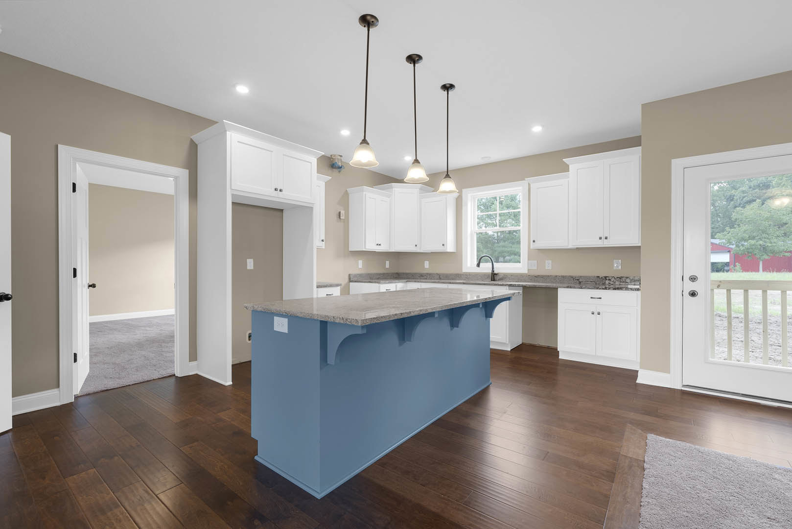 Blue kitchen island with marble countertop, white cabinetry, stainless steel sink, tile flooring, and modern appliances