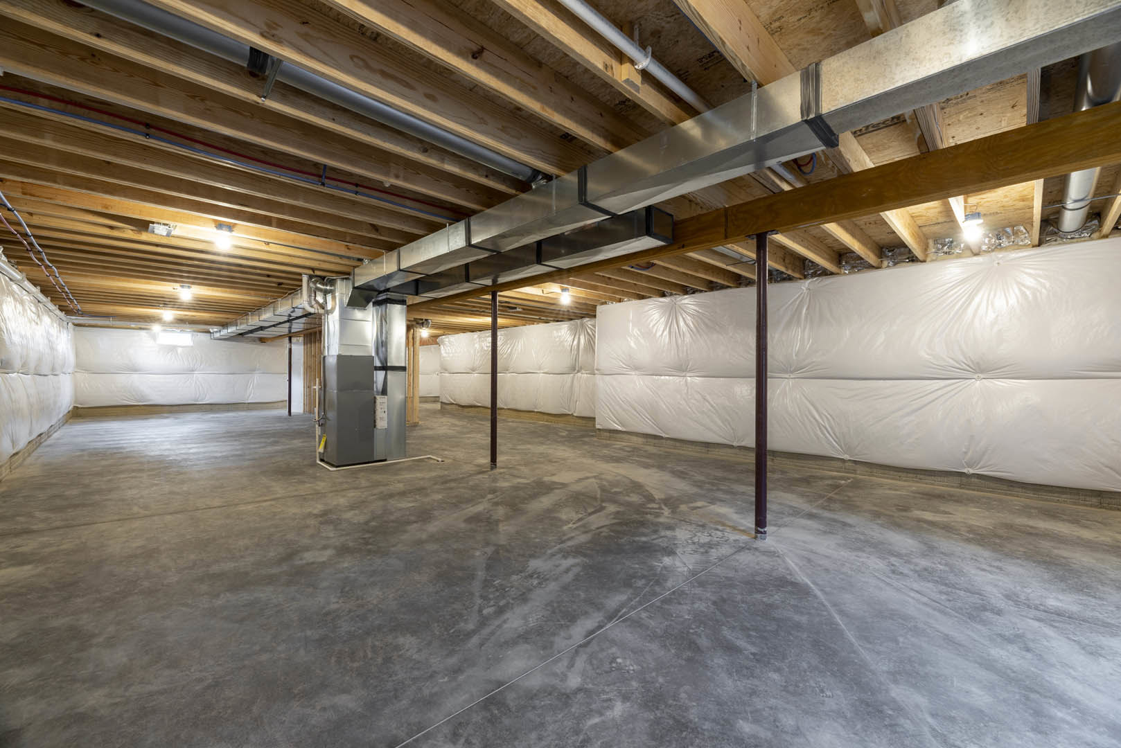 Concrete floor and white wall with metal beam, white plastic wall covering, and close-up of white couch.