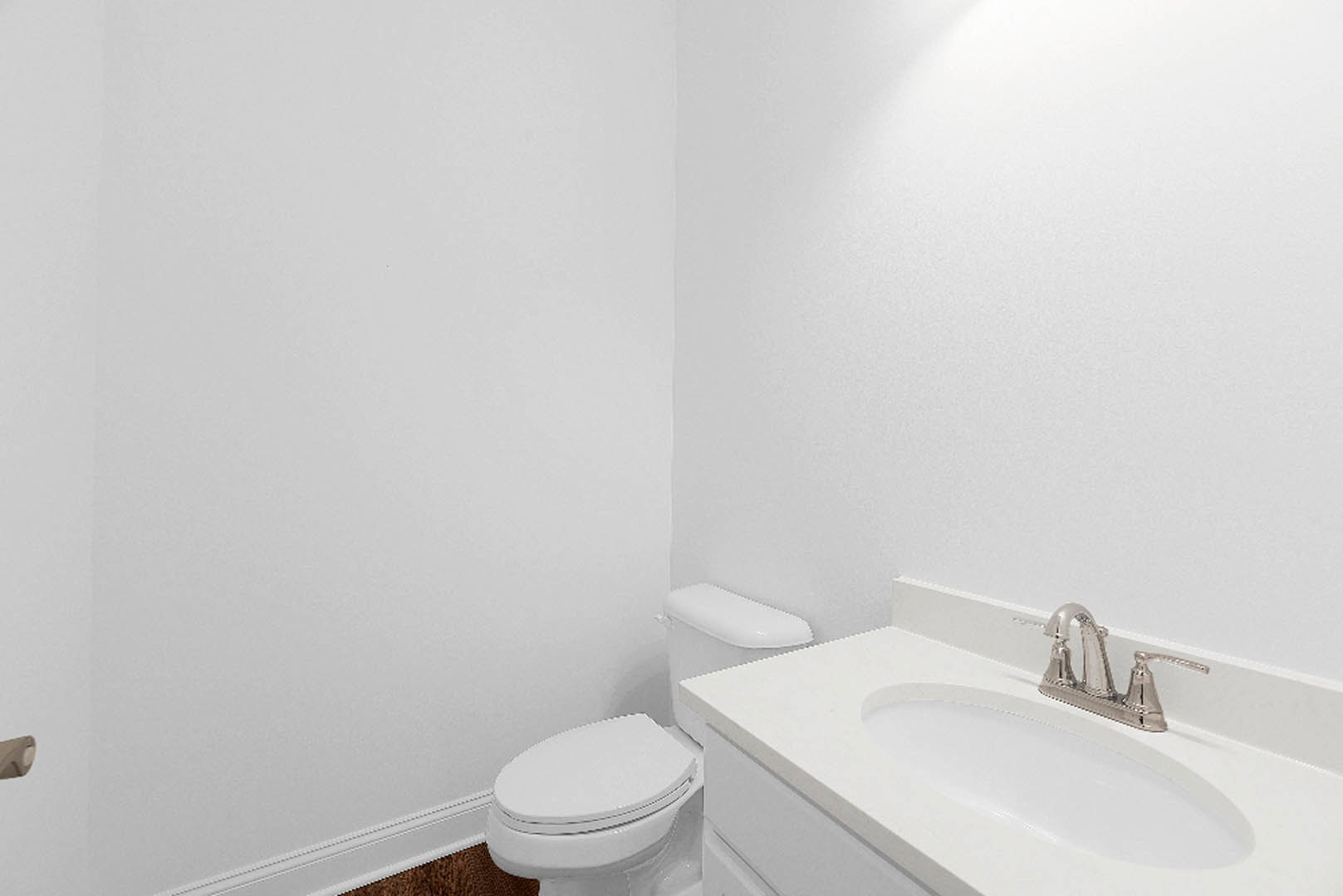 White bathroom featuring a modern sink with chrome faucet, white countertop, and matching toilet against tiled walls