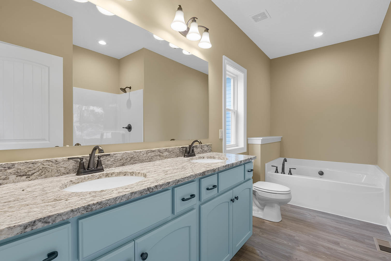 Marble countertop with undermount sink, chrome faucet, white toilet, freestanding bathtub, tile flooring, and window with natural light