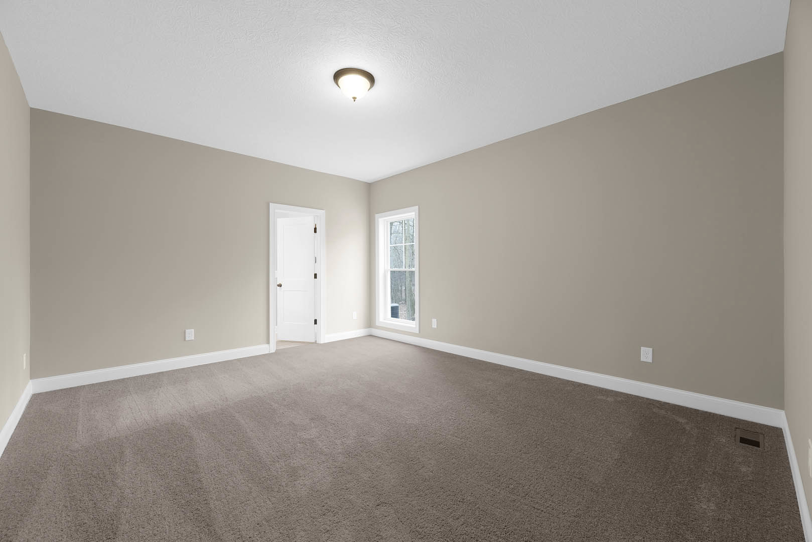 Carpeted room with white walls, white-framed window, white door with gold knob, ceiling-mounted light fixture, crown molding along ceiling edges