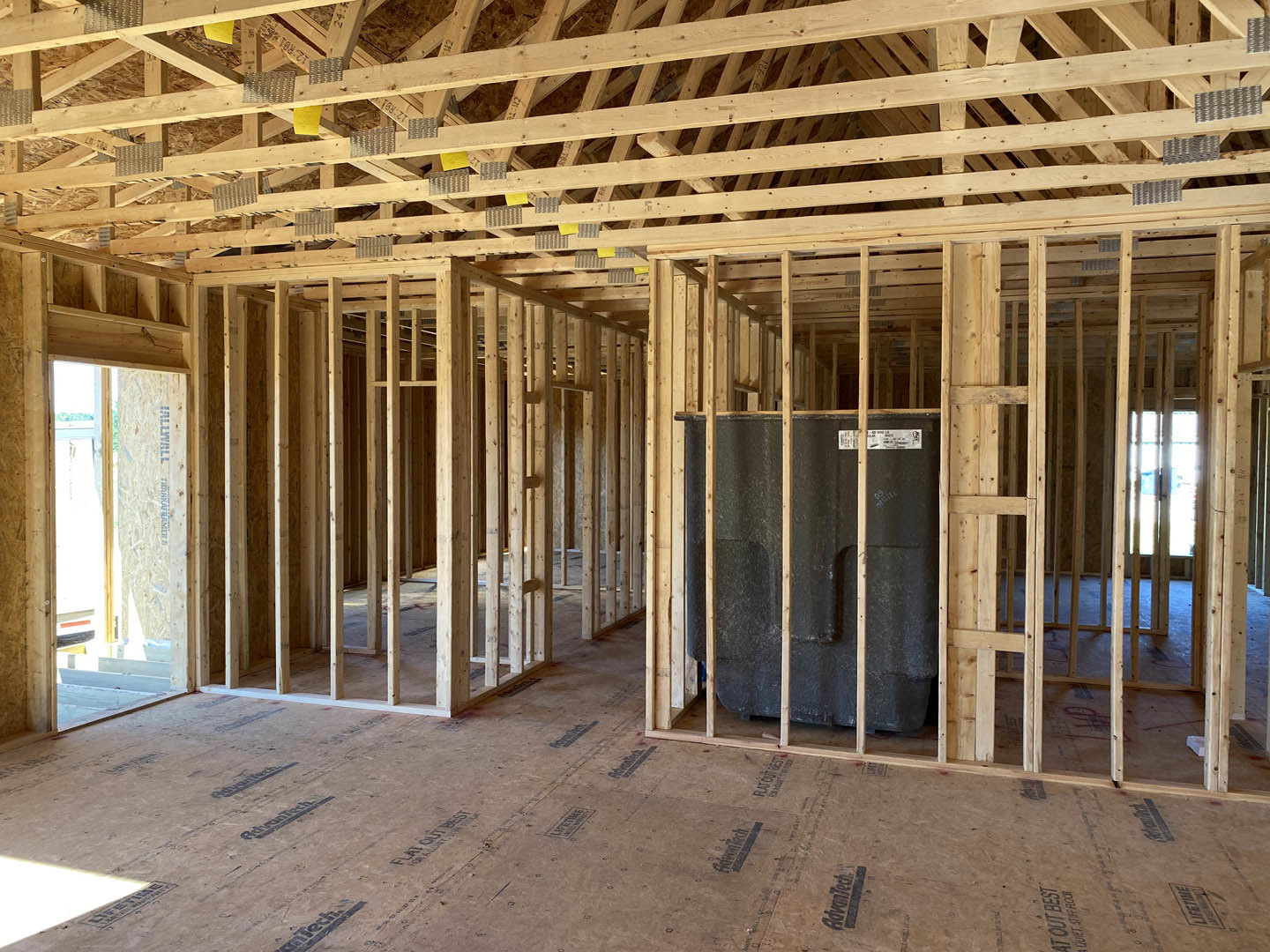 Exposed wood framing with beams and ceiling, unfinished interior construction, visible lumber and insulation