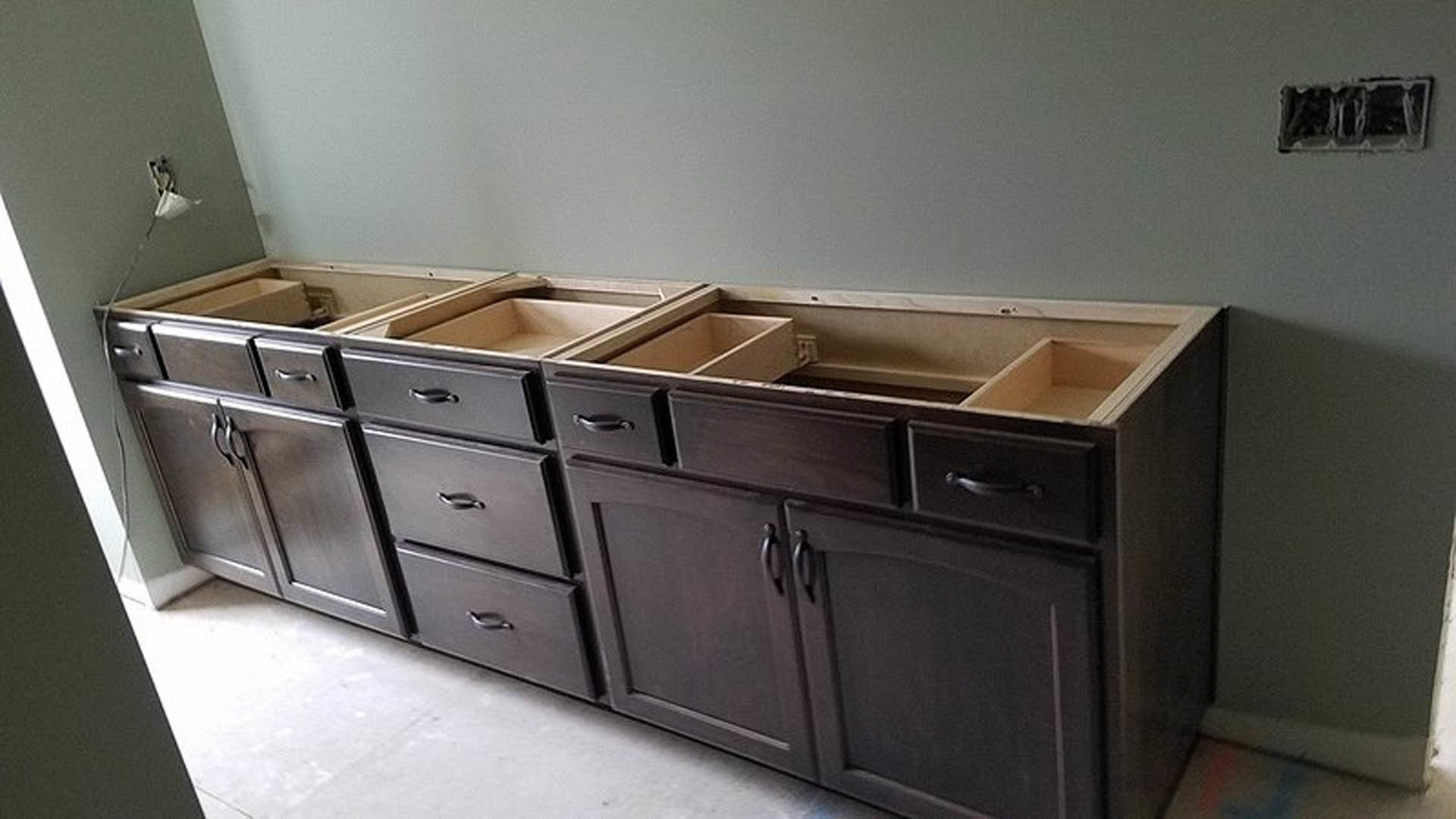 Light wood kitchen cabinets with sleek drawers, white countertop, and a ceramic bowl displayed on the surface