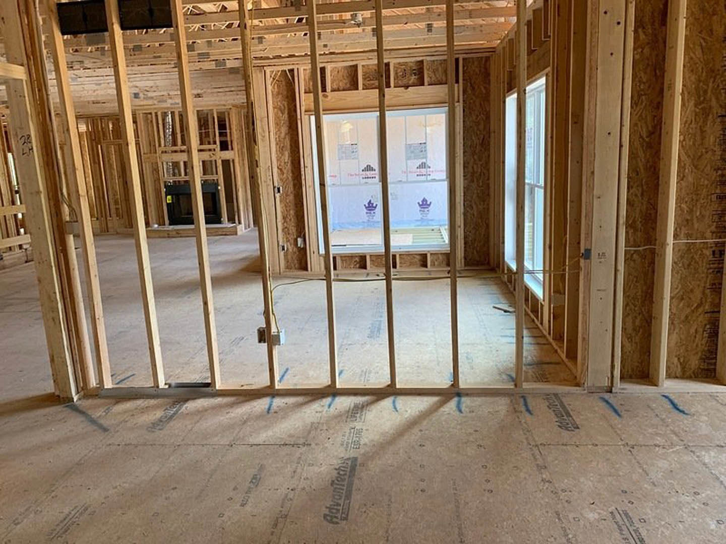 Wood-framed room with exposed beams, glass window, unfinished floor, close-up of wooden post, and built-in bookcase