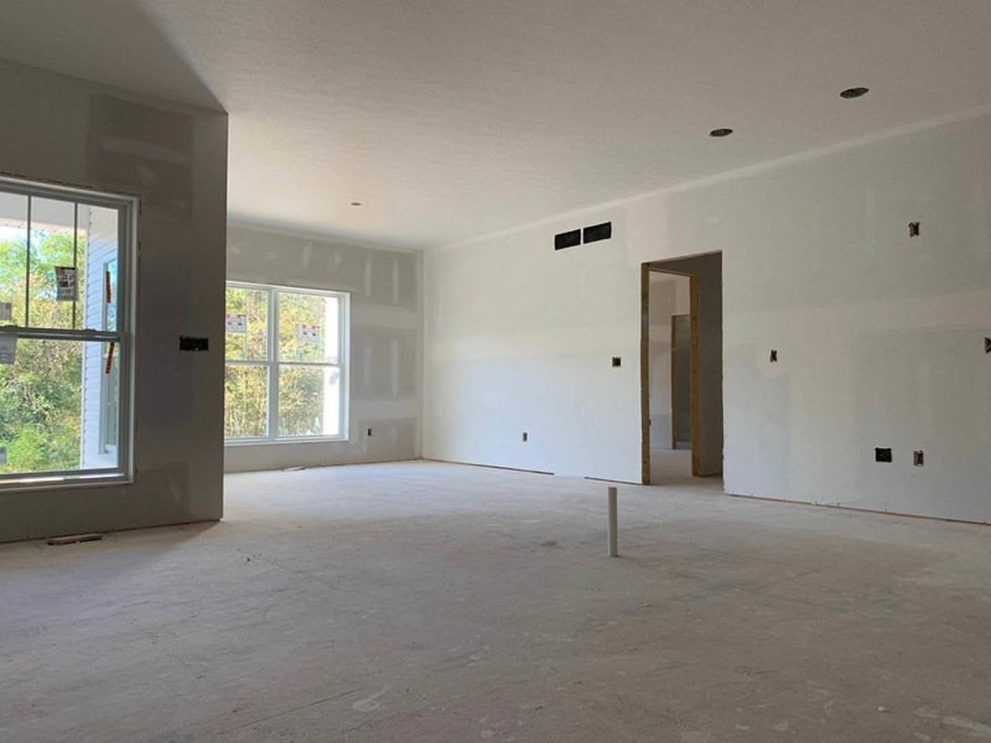 White walls, concrete floor, large window with multiple signs, close-up of door, black rectangles on white surface, minimalist interior