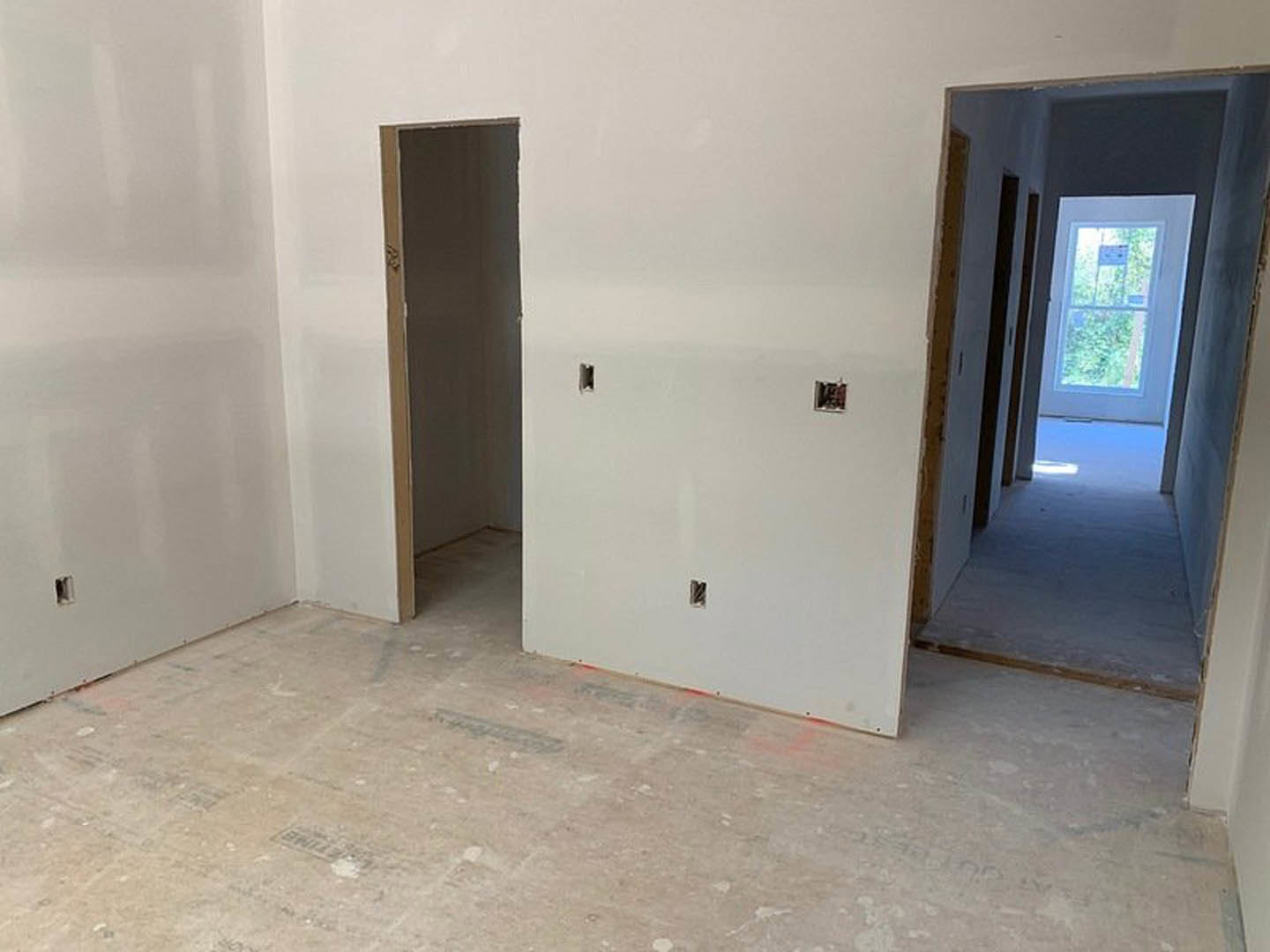 White-walled room with light-colored flooring, single door, and window featuring a small sign.