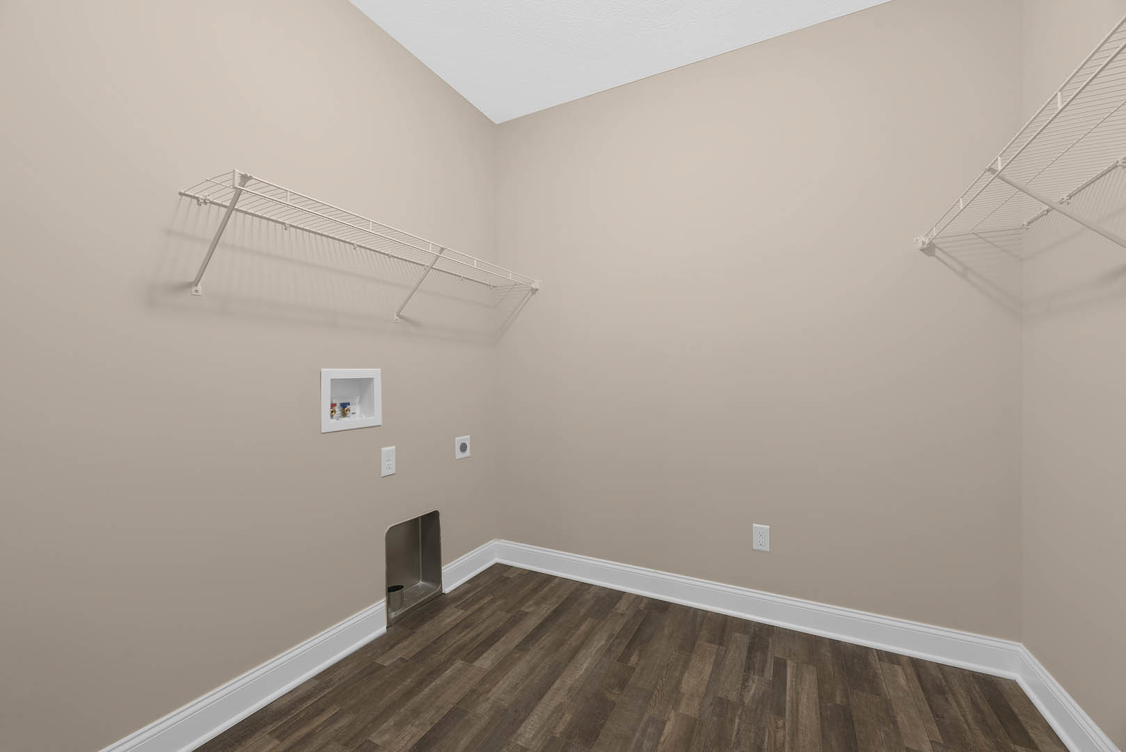 Wood floor with white baseboard, white shelving unit featuring a long bar, metal bin recessed in wall, white utility box with valves, plaster walls and ceiling