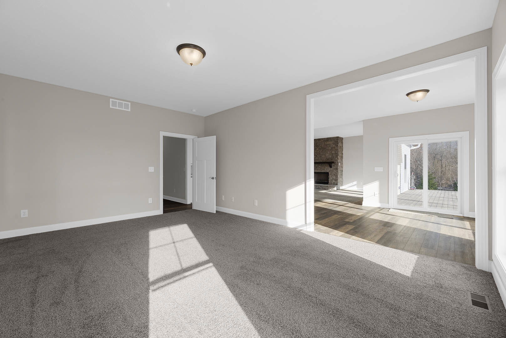 Open white door with silver handle leading to patio, light fixture on ceiling, tile flooring, plaster walls, and decorative molding