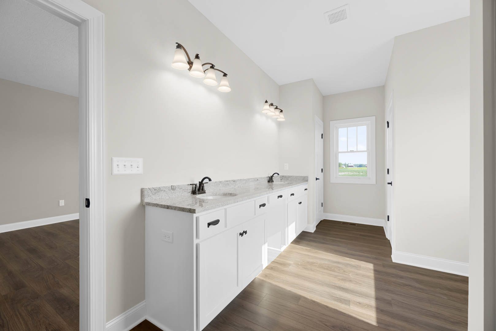 Bathroom featuring white cabinetry, marble countertops, chrome faucet, four-light fixture, tile flooring, and window overlooking a grassy field