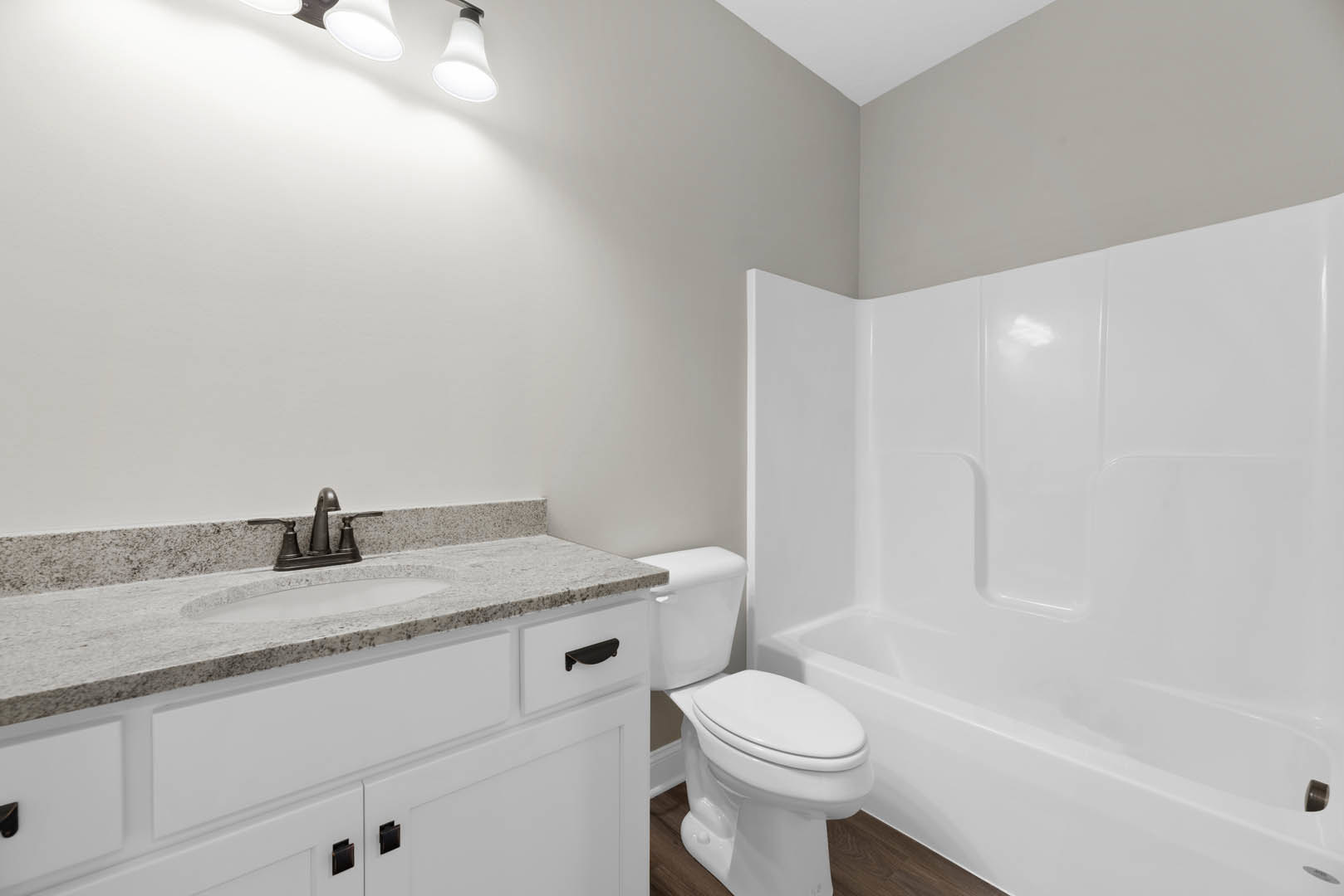 White bathtub and toilet with chrome faucet and tile walls in a modern bathroom