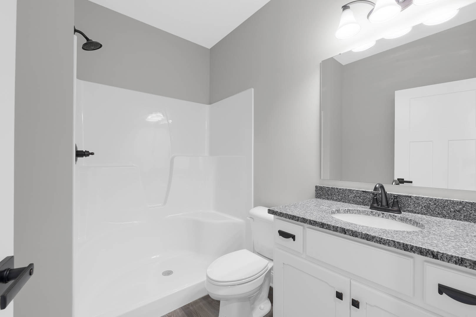 Modern bathroom featuring a white toilet, rectangular sink with chrome faucet, tiled walls, glass shower enclosure, and recessed lighting fixture