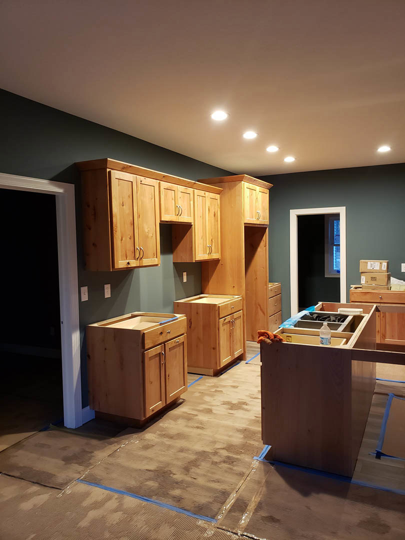 Kitchen featuring natural wood cabinets and matching island, white quartz countertops, stainless steel sink, light hardwood flooring, and recessed lighting.