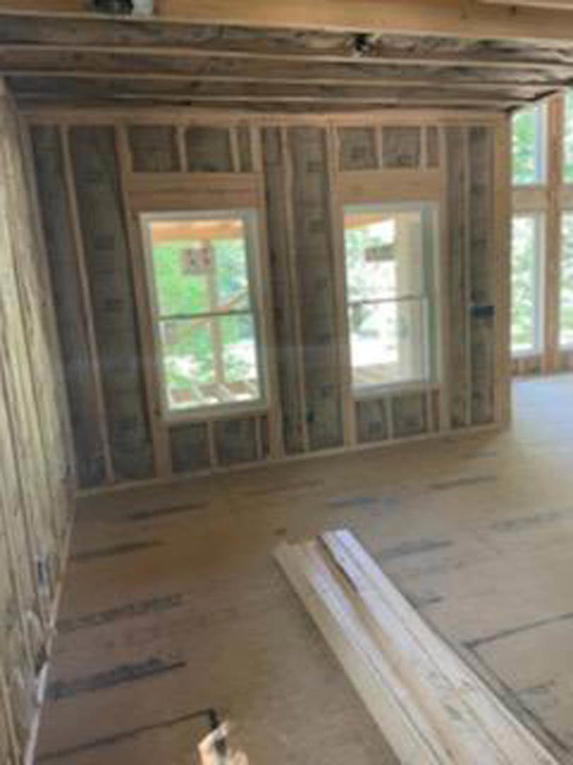 Living space featuring wood plank walls, multiple windows, and natural light highlighting hardwood finishes