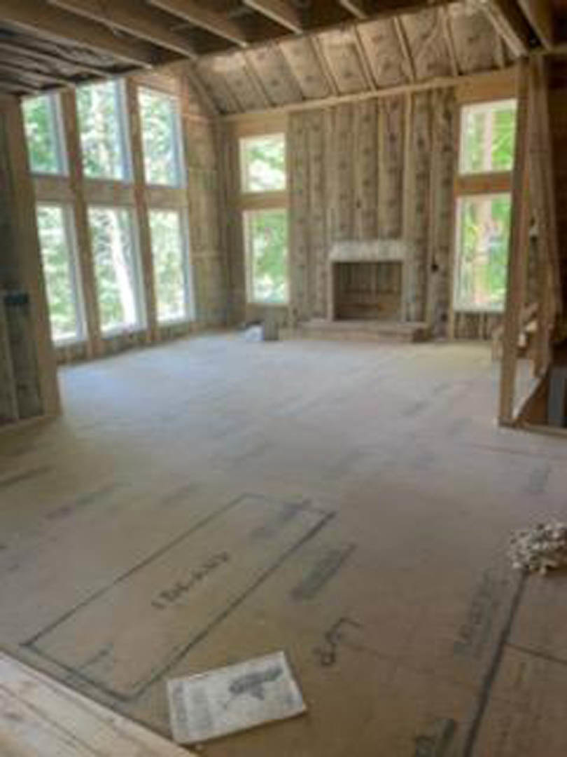 Sunlit room with wide plank hardwood flooring, large windows, and neutral walls