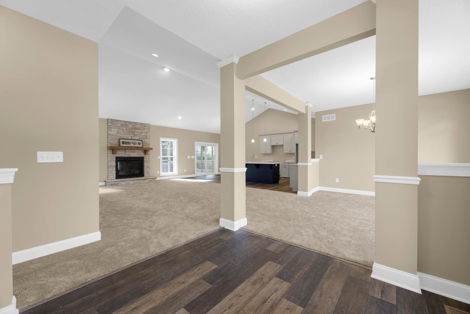 Living room featuring black glass fireplace, wood flooring with white baseboards, white door with glass panes, and large window