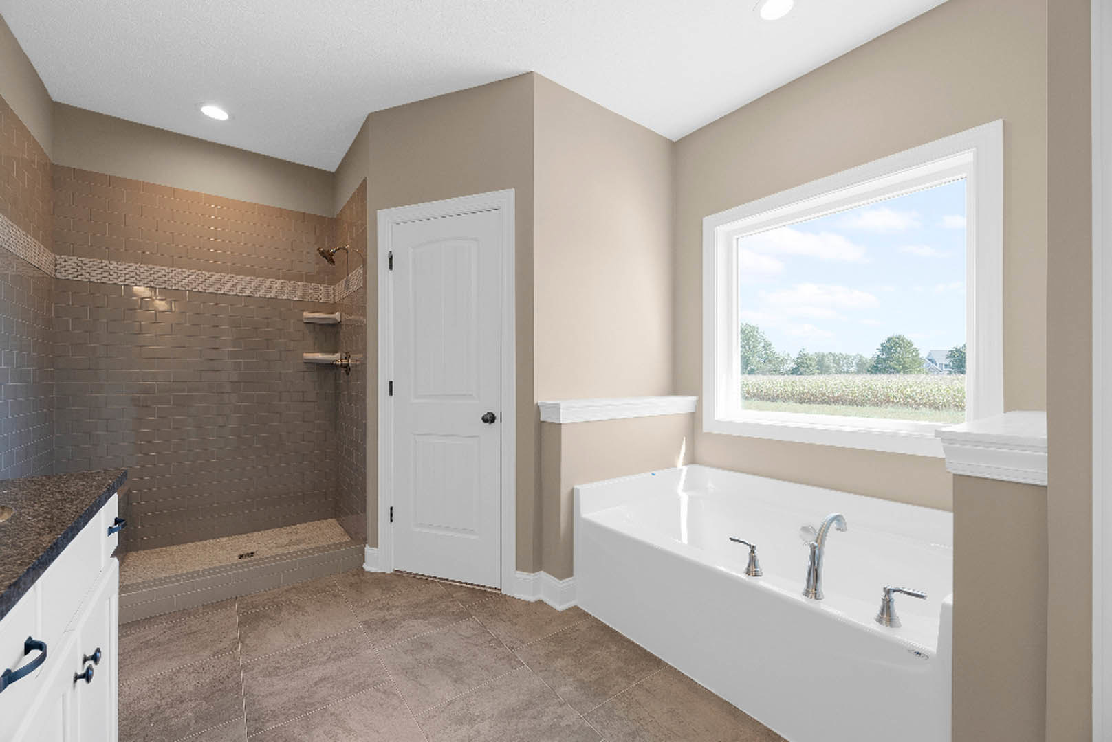 Bathroom with freestanding bathtub and glass-enclosed shower, white tile walls, white cabinet with black handle, window overlooking field of flowers, blue plastic strap resting on