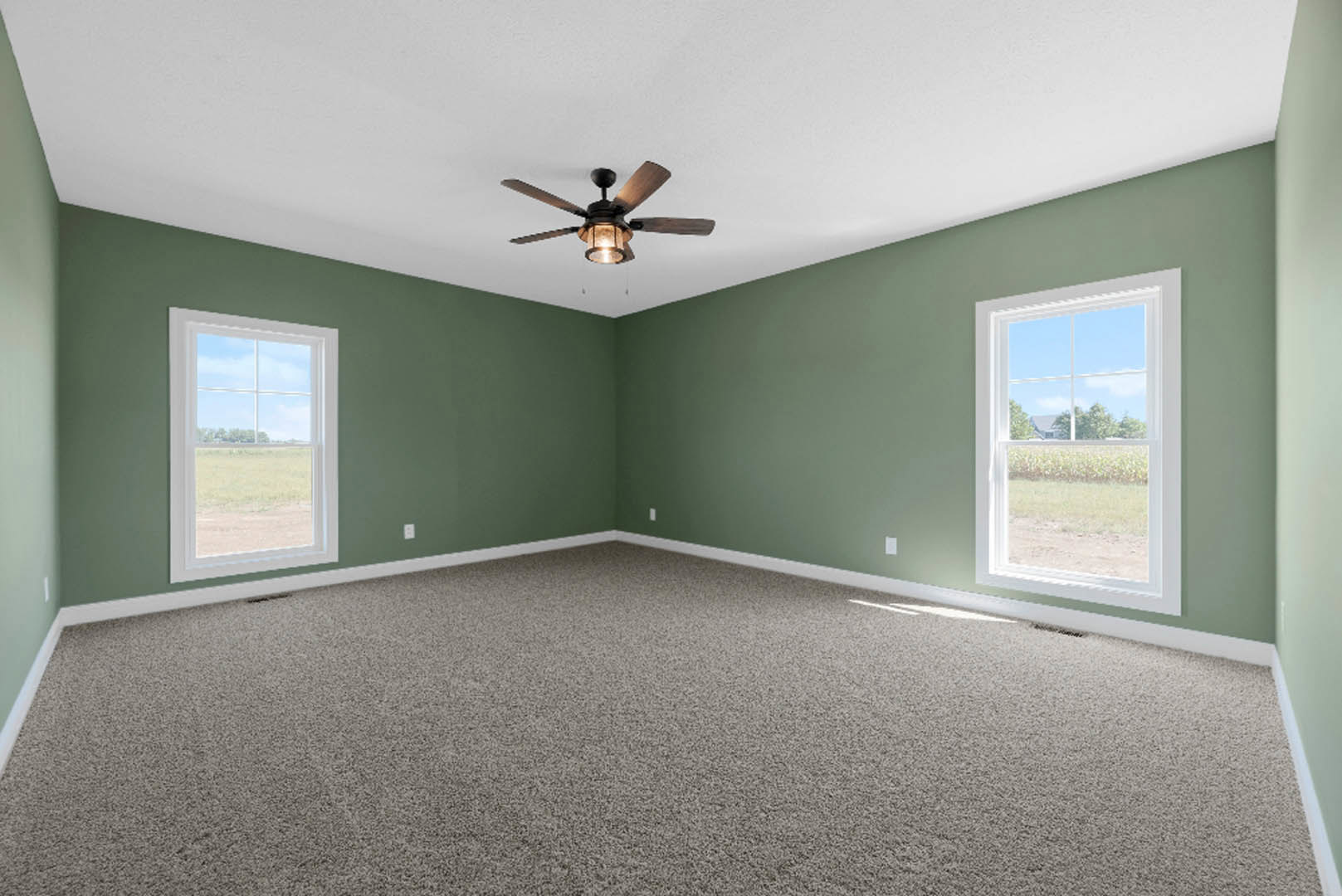 Green-walled room with carpet flooring, ceiling fan with light, and window overlooking a field and trees