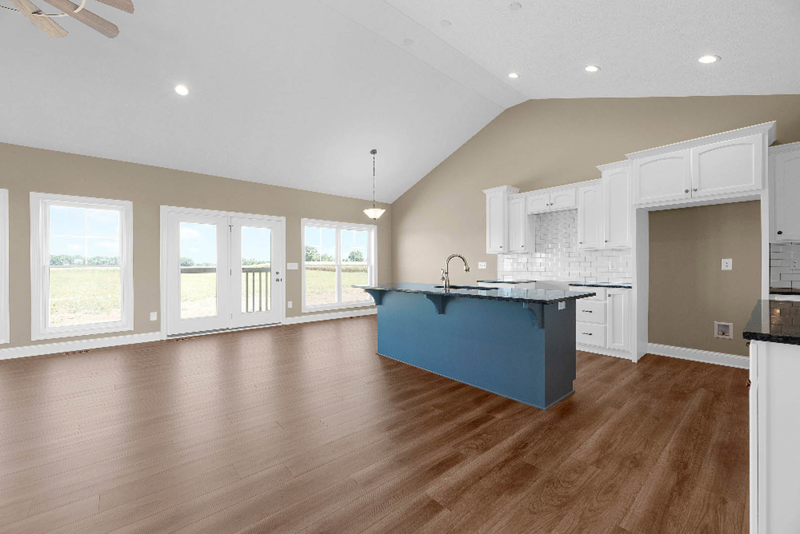 Blue kitchen island with silver faucet, wood flooring, white cabinetry, glass double doors, large window overlooking a field, and light-colored walls.