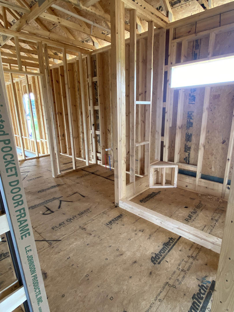Exposed wood framing and beams with visible insulation during home construction