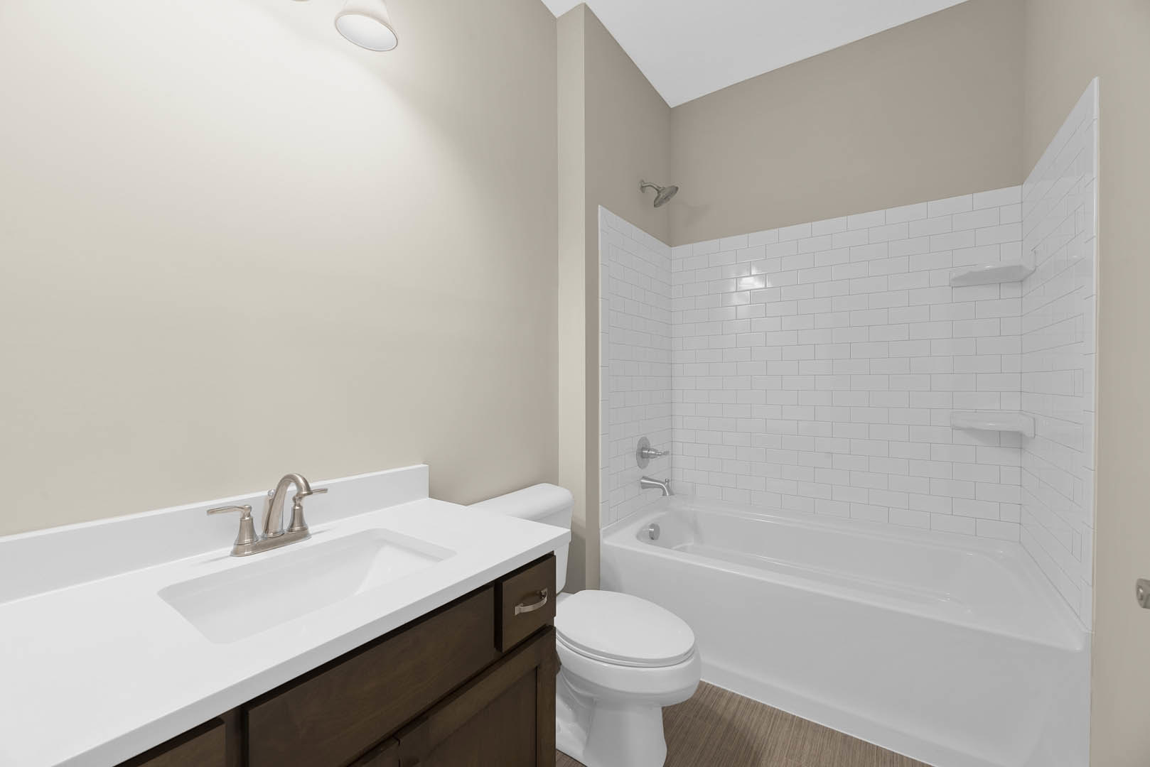 Modern bathroom with white ceramic sink, chrome faucet, white toilet, and freestanding bathtub, surrounded by light tile walls and floor.