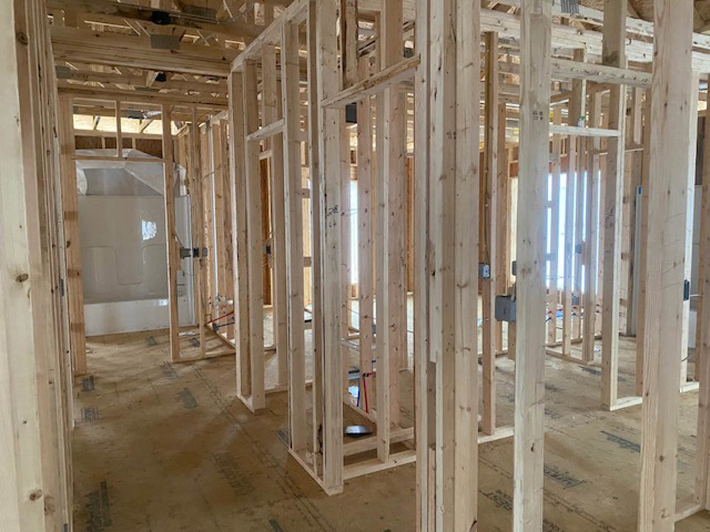 Exposed wooden framing and beams with visible insulation during home construction