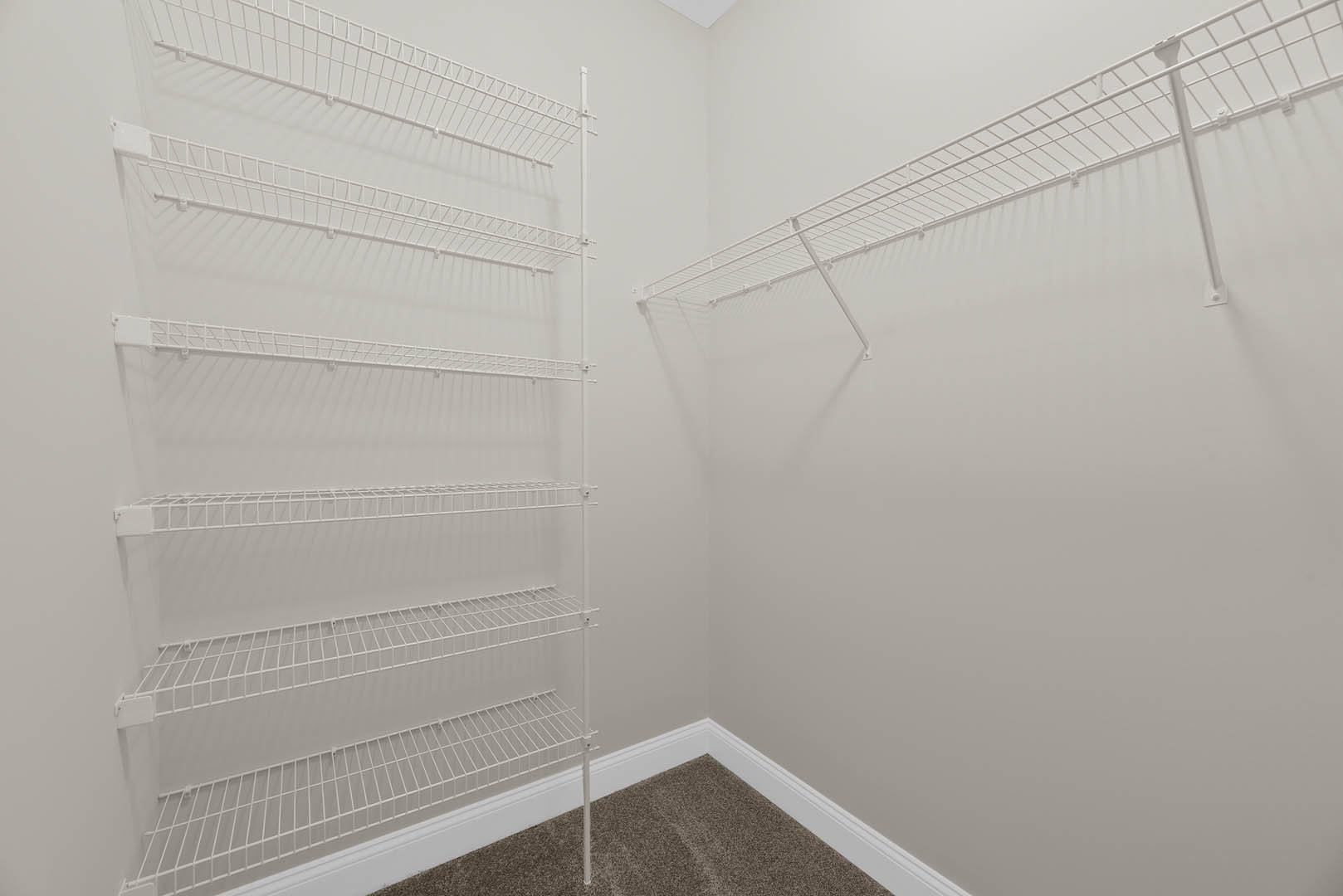 White built-in shelves mounted on a smooth white wall in a bright indoor room.