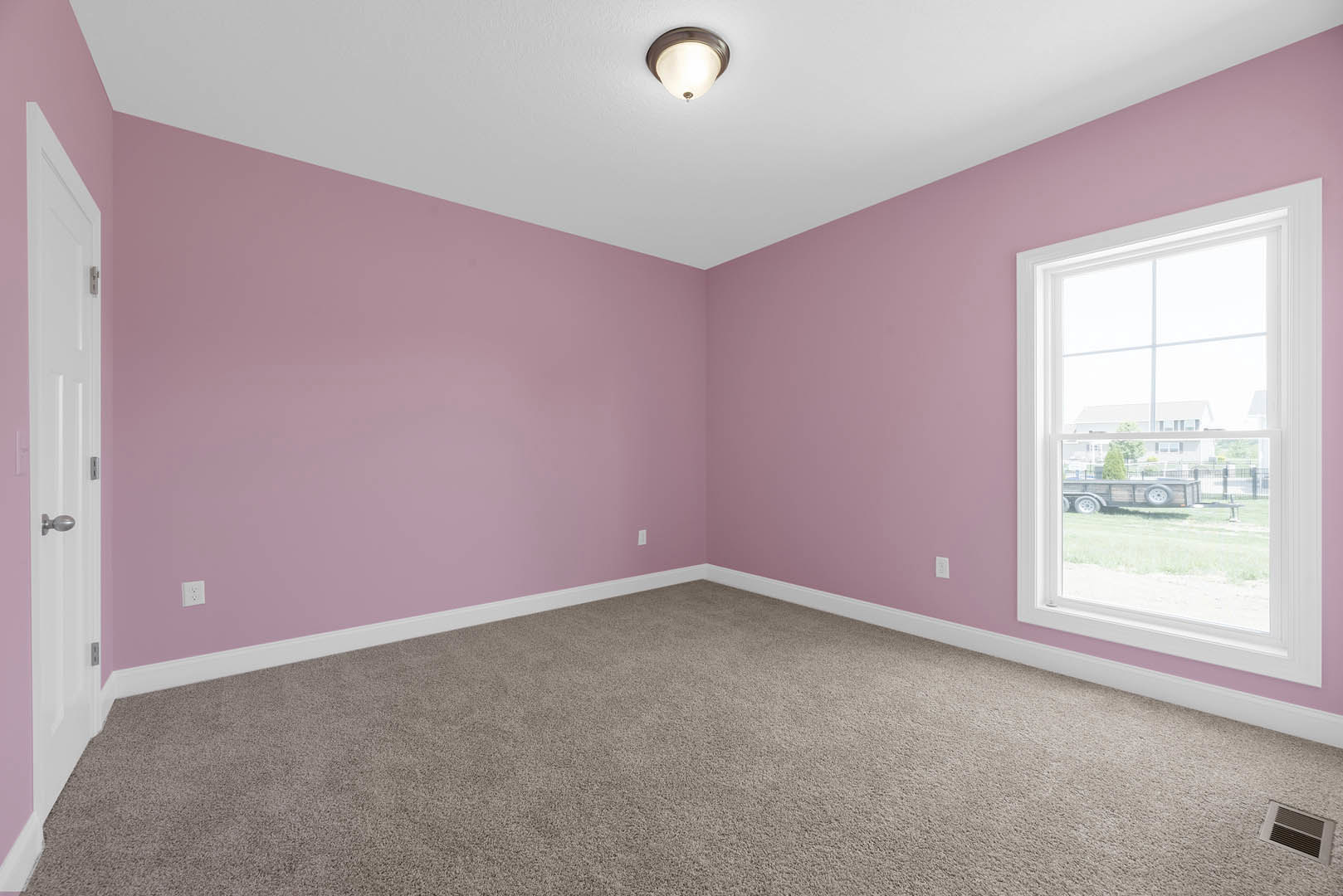 Carpeted room with pink walls, white ceiling, window overlooking a trailer, floor vent, and close-up of a modern light fixture