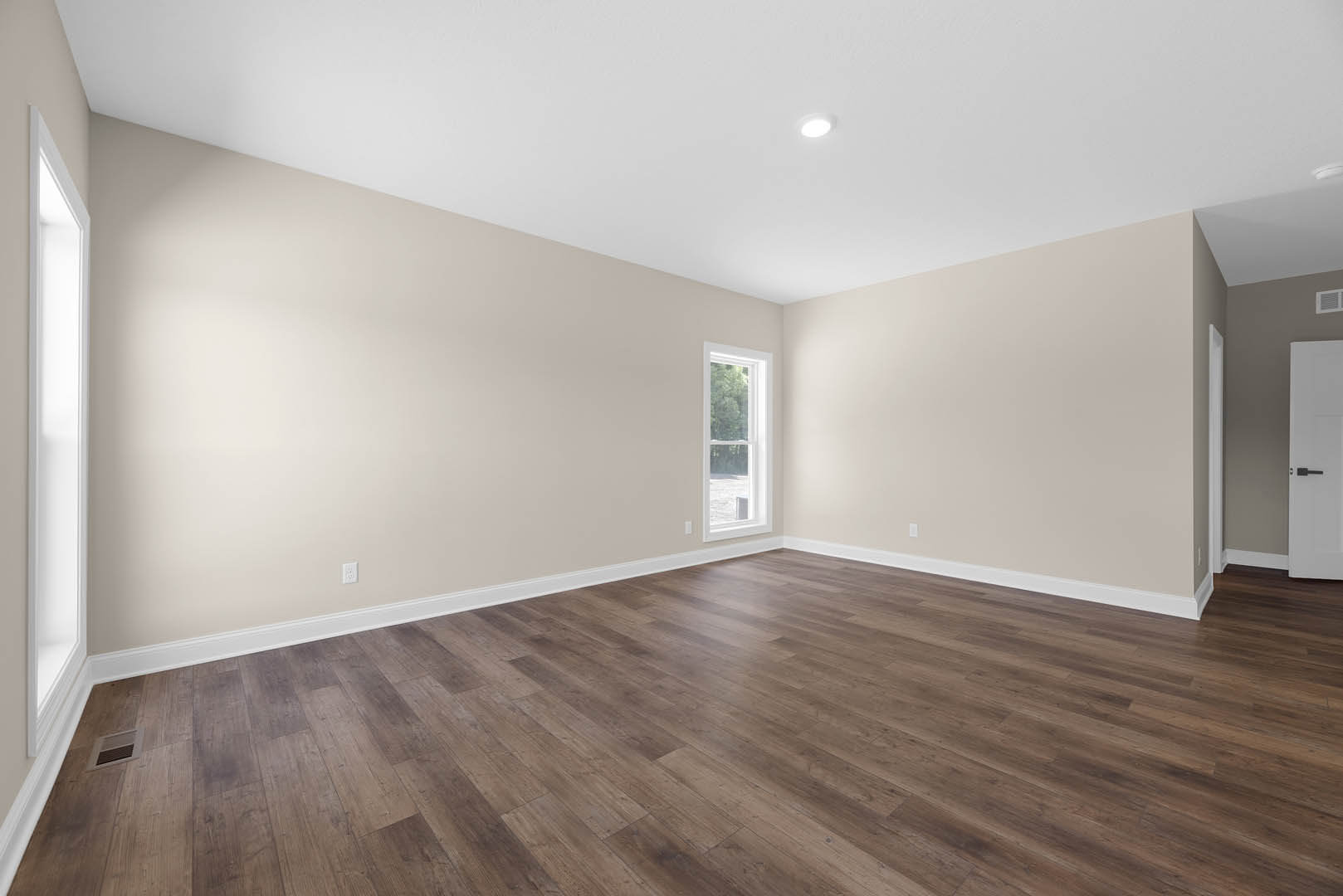 Hardwood floor with white-framed window, white walls, door handle, and wall vent; tree visible outside window