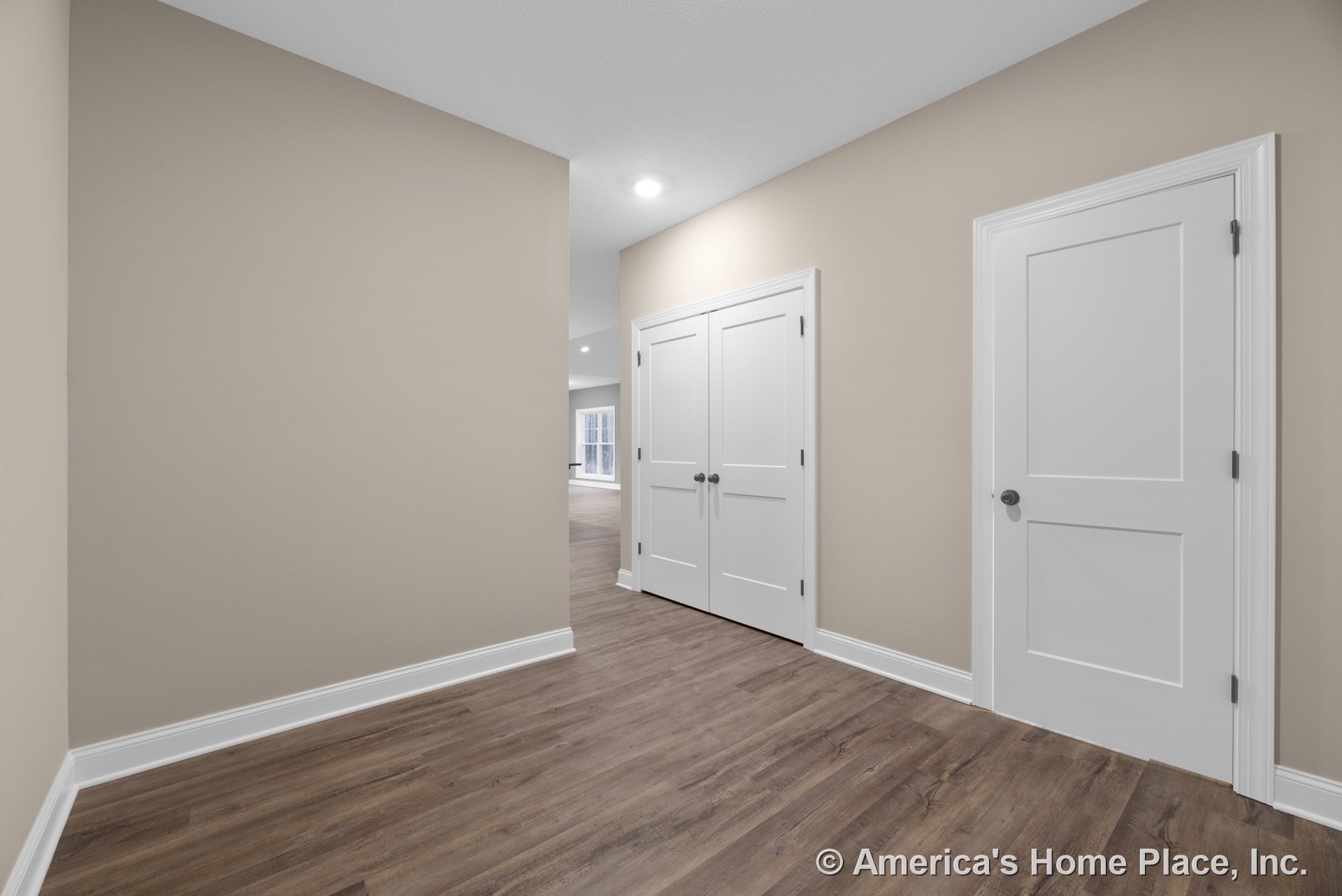 Entry hallway with wood-look plank flooring, beige painted walls, white baseboard trim, recessed ceiling lighting, double white paneled closet doors, and single white interior
